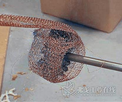 清洁机筒的第一步是在一根加长杆的末端将铜纱布绕在一把圆钢丝刷的外径上